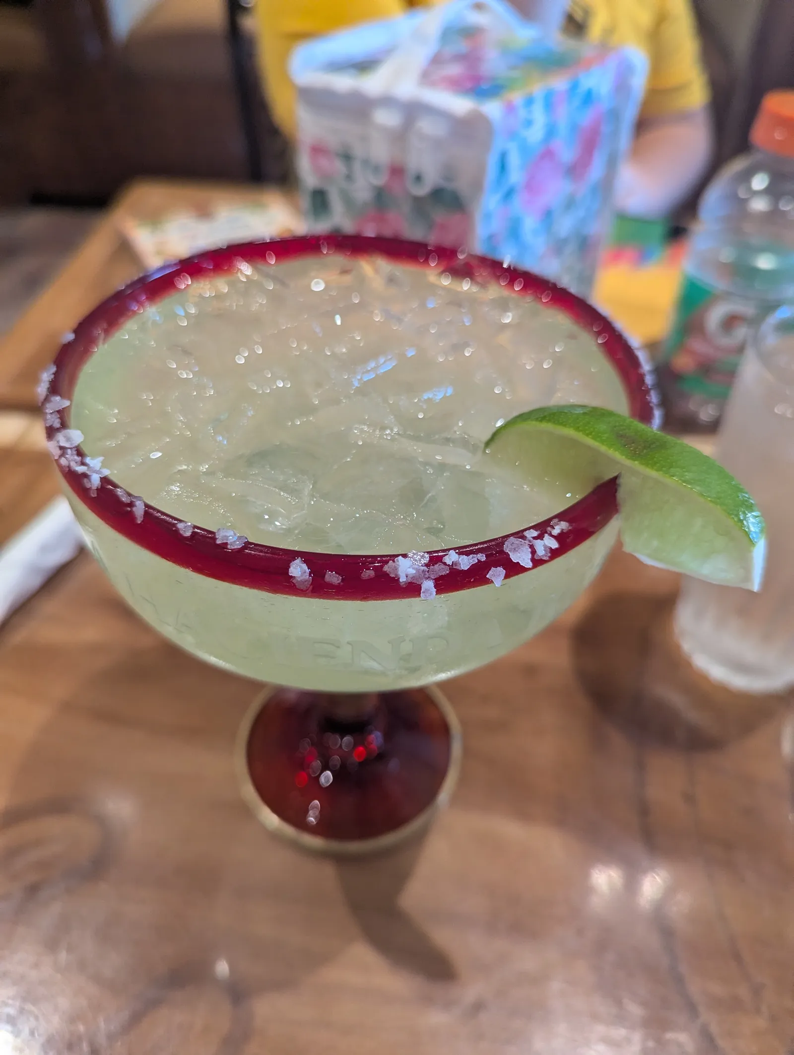 A margarita flight of four glasses on a wooden paddle
