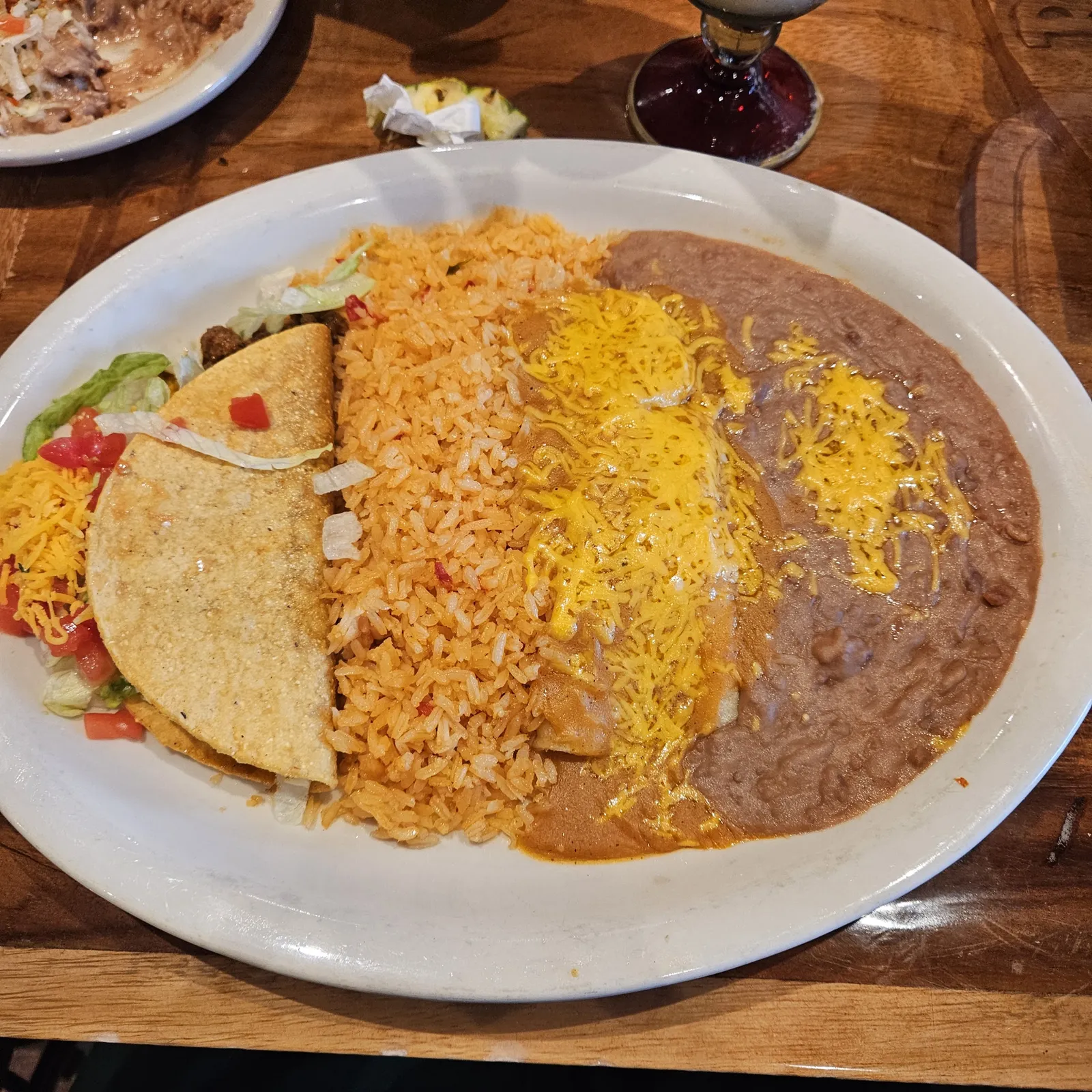 A stack of fresh tortillas in a cloth-lined basket on a dark wood table